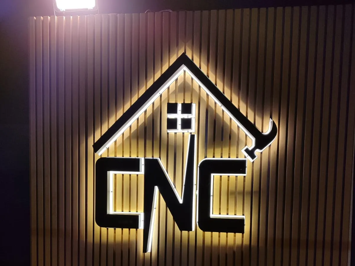 شعار CNC على شكل منزل بإضاءة خلفية على جدار شرائح