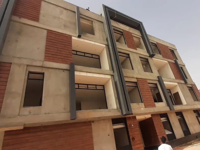 عمارة سكنية بإطارات كلادينج رمادية وألواح بلون الخشب