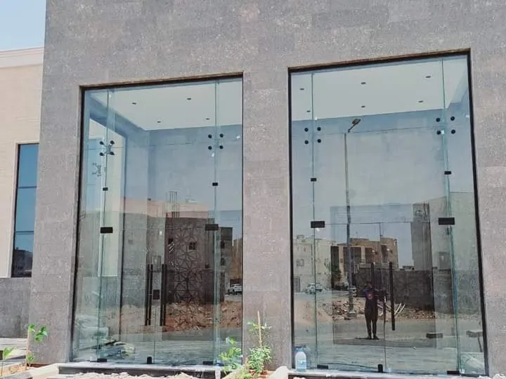 واجهتا محلين زجاجيتان داخل إطار حجري مع درج أمامي