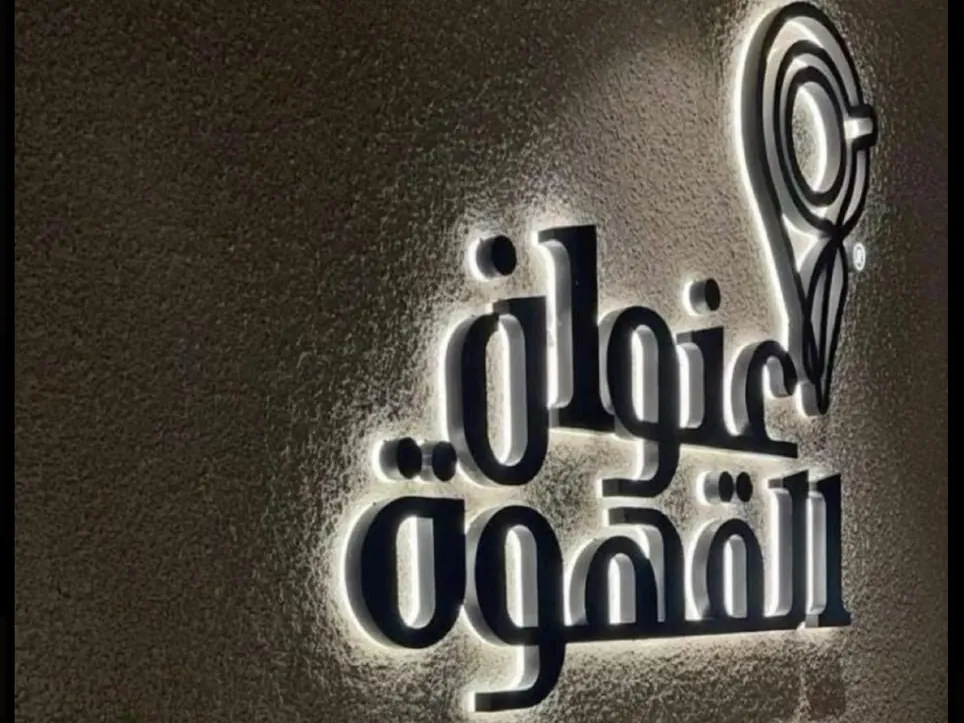 أحرف عنوان القهوة البارزة بإضاءة خلفية على جدار داخلي